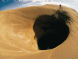 A Mountain Biker Cycles Around a Spectacular Crater in the Desert