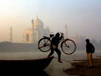 An Unidentified Cyclist Gets Down with His Cycle against the Backdrop of the Taj Mahal