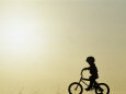 Silhouette of Boy Riding a Bicycle